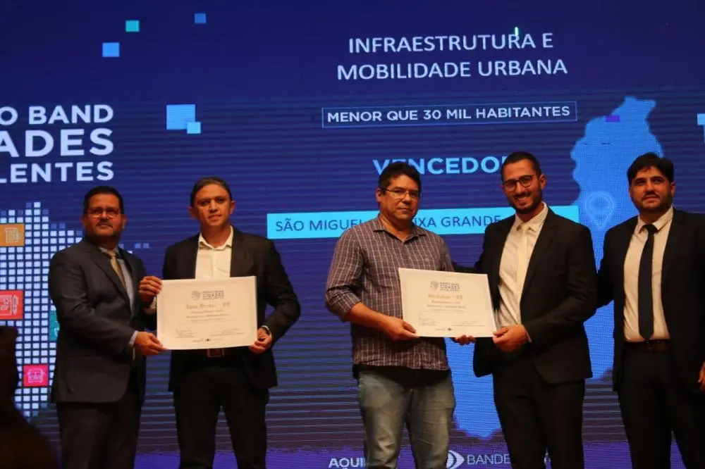 Prefeito Junior Ribeiro do lado esquerdo recebendo o prêmio