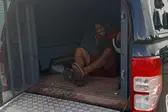 O agressor ainda esboça sorriso ao descer da viatura da Polícia Civil (Foto: )
