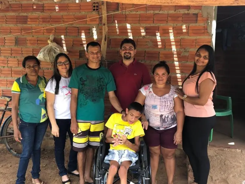 Dr. Eduardo Claudino entrega cadeira de rodas ao paciente.