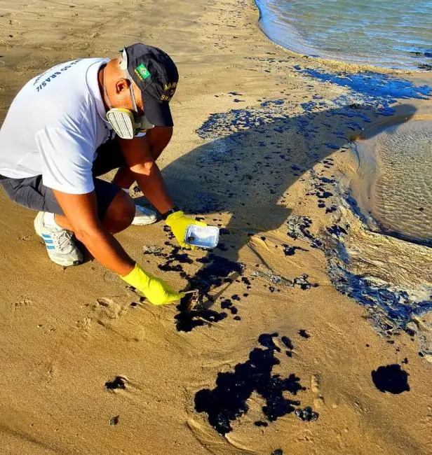 Servidor da Marinha coleta amostras das manchas de óleo em praia do Ceará — Foto: Divulgação/Marinha