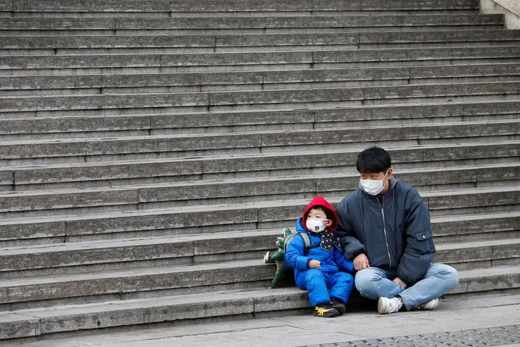Um homem com seu filho, ambos de máscara, em Seul, na Coreia do Sul - Reuters/Heo Ran/direitos reservados