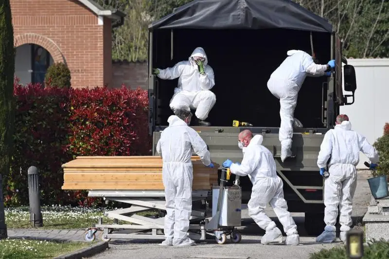 Coronavírus na Itália: caixões são baixados no cemitério de Ferrara, norte do país, a partir de um comboio militar vindo de Bergamo, cidade no epicentro do surto do vírus no norte da Itália, sábado (21) — Foto: Massimo Paolone/LaPresse via AP
