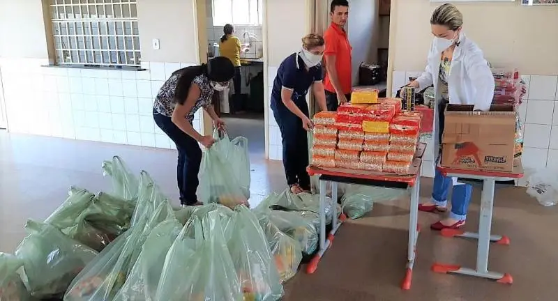 Nutricionista da SME fazendo a entrega dos alimentos.
