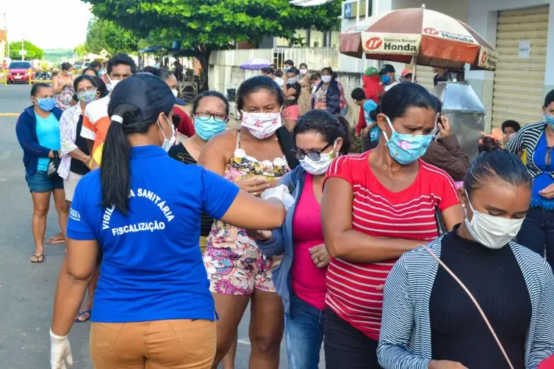 Agente da Vigilância Sanitária distribuindo álcool em gel.