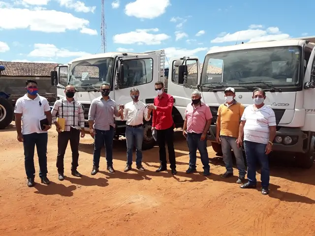 Prefeito e equipe recebendo as chaves dos caminhões