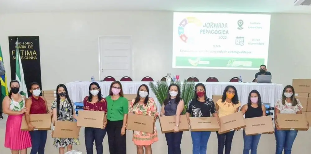 Secretária de Educação Lêda Maria realizando a entrega de notebooks aos professores.